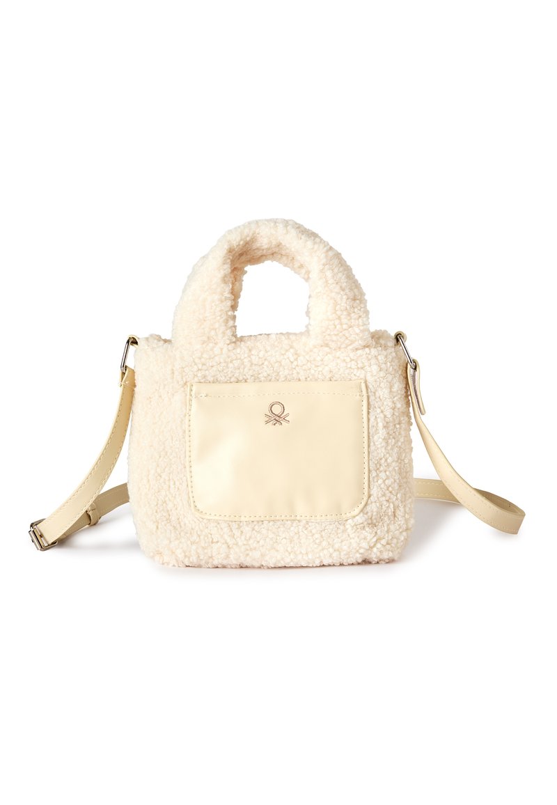 Kremowa torebka z pluszowym, teksturowanym korpusem, skórzaną przednią kieszenią, podwójnymi uchwytami i odpinanym paskiem na ramię.