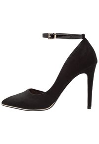Scarpa con tacco alto in suede nero, punta affusolata, cinturino alla caviglia e dettaglio metallico lungo la suola. Texture liscia e design elegante.