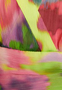 Tissu multicolore avec des motifs vibrants en rose, vert et jaune. Texture plissée avec des éléments de design en diagonale et des accents lisses.