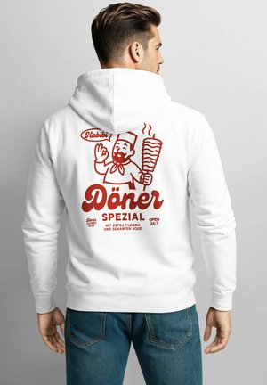 Mann in weißem Hoodie mit rotem Grafiken eines Küchenchefs, der einen Döner Kebap hält, sowie Text, der ein Döner-Special auf der Rückseite auf Deutsch bewirbt.