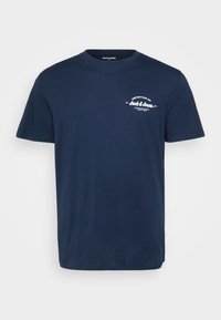 Μπλε βαμβακερό T-shirt με κοντά μανίκια, στρογγυλή λαιμόκοψη και λευκό κείμενο ως γραφικό στην αριστερή πλευρά του στήθους, με καμπύλη σχεδίαση.