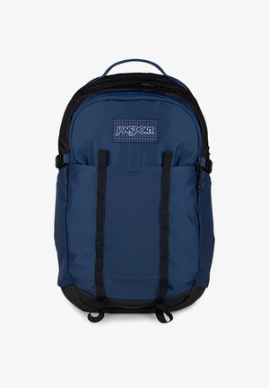 Niebiesko-czarny plecak Jansport z przednimi paskami na klatkę piersiową, górnym uchwytem i dwiema kieszeniami na zamek na białym tle.