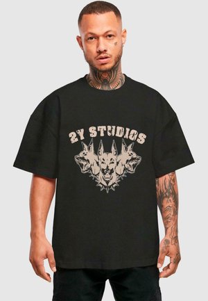 Musthave musträti mustä t-särk, millel on graafiline kujundus kolme koera pea ja "2Y STUDIOS" kulunud beežide tähtedega. Lühikesed varrukad, vabam lõige.