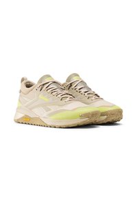 Beige sportcipők sárga részletekkel, texturált hálós felsőrész, lapos fűzők és strapabíró talp, amelyen a "Vibram" logó található.