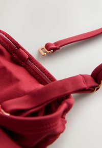 Vīnsarkanā krūšturis ar mīkstu audumu, regulējamām lencēm un rožu zelta detaļām. Kopā ar smalku šuvju detaļu un bezšuvju dizainu.