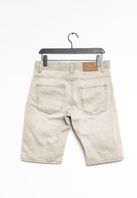 Bermudas de algodón beige con un ajuste slim, que cuentan con dos bolsillos traseros y un parche de cuero marrón en la cinturilla. Dobladillo recto con textura mínima.