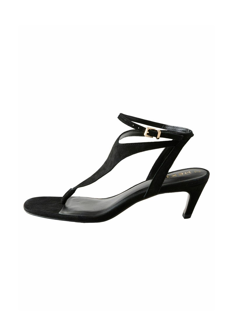Sandal con tacco in suede nero caratterizzato da un design con T-strap, cinturino alla caviglia regolabile con fibbia dorata e punta affilata ed elegante.