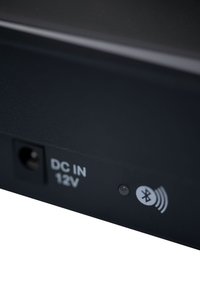 Bluetooth device with a matte black finish. Features a DC input labeled "DC IN 12V" and an illuminated Bluetooth indicator.