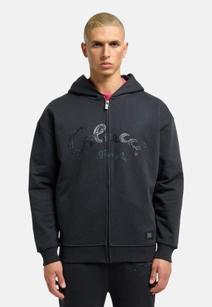 Black zip-up hoodie made from soft material, featuring a hood, ribbed cuffs, and a decorative logo in shimmering detail on the front.