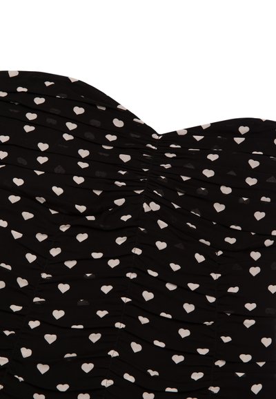 Robe noire avec fronces horizontales, ornée d'un motif de cœurs blancs. Le tissu est léger et lisse, mettant en valeur le design structuré.