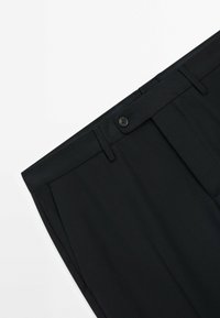 Black trousers with a flat front, single button closure, belt loops, and subtle crease detailing. Made from a smooth fabric with a tailored fit.