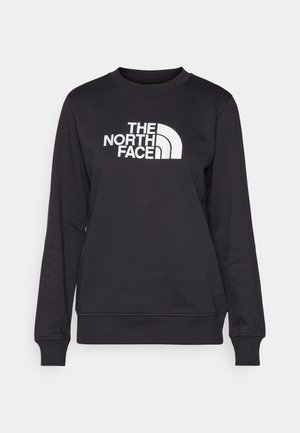 Črna dukserica s širokim ovratnikom, dolgimi rokavi, rebrastimi zapestji in belim logotipom "The North Face" v središču spredaj. Gladka tekstura.