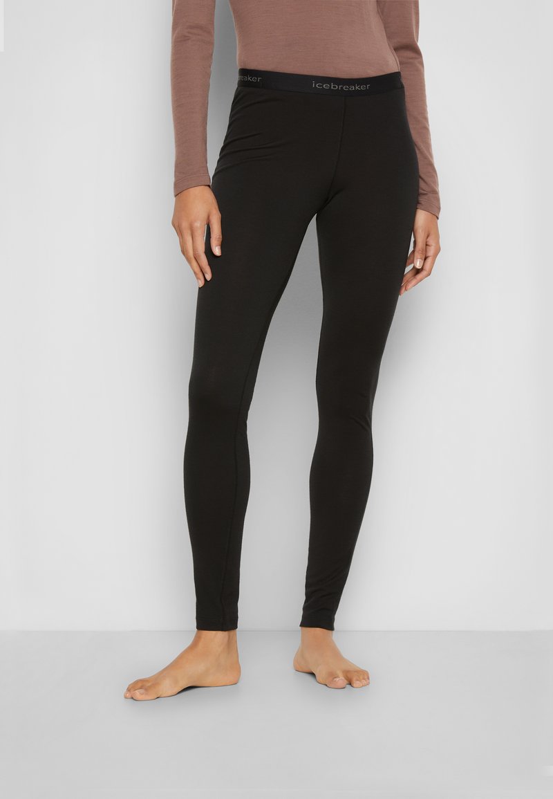 Zwarte leggings van rekbaar materiaal met een gladde textuur, voorzien van een brede zwarte tailleband met het label "icebreaker."