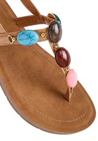 Sandal in finta pelle marrone con una soletta texturizzata. Caratterizzato da una fascia intersuola decorata con quattro ovali colorati: turchese, marrone scuro, bordeaux e rosa.