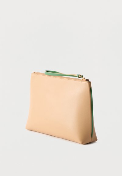 Pochette rectangulaire beige à fermeture éclair avec une lanière verte pour poignet et une doublure intérieure verte, positionnée debout sur un fond clair uni.