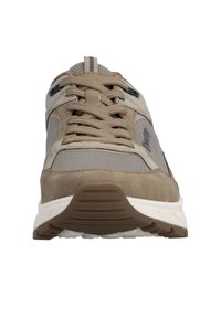 Beiger und grauer Sportschuh mit dicker Sohle, abgerundeter Zehenpartie, Obermaterial aus Mesh und Wildleder sowie braunen Schnürsenkeln, die vorne gebunden sind.