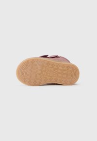 Velcro sportschoen met een paarse suède bovenkant, voorzien van een rubberen zool met een gestructureerd grippatroon en een geperste logo aan de zijkant.