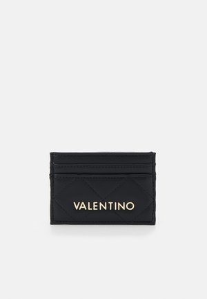 Musta tikattu nahkainen korttikotelo, jossa on kolme korttipaikkaa ja etupuolella kultainen Valentino-logo valkoista taustaa vasten.