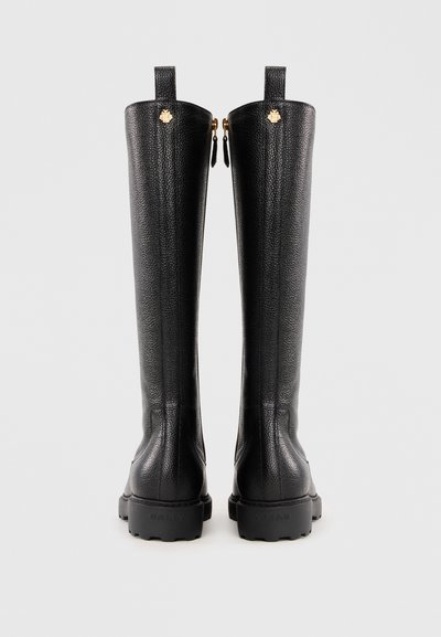 Bottes en cuir noir arrivant au genou avec une finition texturée, des accents en matériel doré et une semelle en caoutchouc épaisse. Fermetures éclair à l'arrière.
