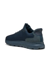 Zapatillas deportivas azul marino con una parte superior de punto transpirable, acentos de cuero suave y una suela de goma acolchada con patrones en forma de ola.