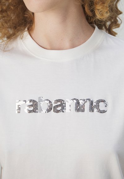 T-shirt en coton blanc avec le mot "rabanne" en sequins argentés. Le design a un col rond classique et une texture lisse.