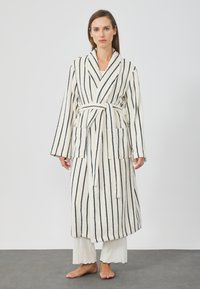 Csíkos fürdőköpeny krém és tengerészkék színben, vastag, textúrált anyagból készült. Légyen benne sállap, öv és két elülső zseb.