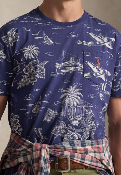 Μπλε βαμβακερό t-shirt ναυτικού χρώματος με λευκές ναυτικές εικόνες, όπως πλοία, φοίνικες και σύννεφα. Περιλαμβάνει λεπτομέρεια με τσέπη.