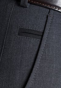 Donkergrijze broek met een gladde textuur, een subtiel patroon en een klein, zwart insetzakje. Afgewerkt met een riemlus.