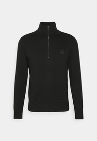 Svart zip-neck pullovertröja i slät stickad kvalitet. Har långa ärmar, ribbad mudd och nederkant samt en liten logotypåse på bröstet.