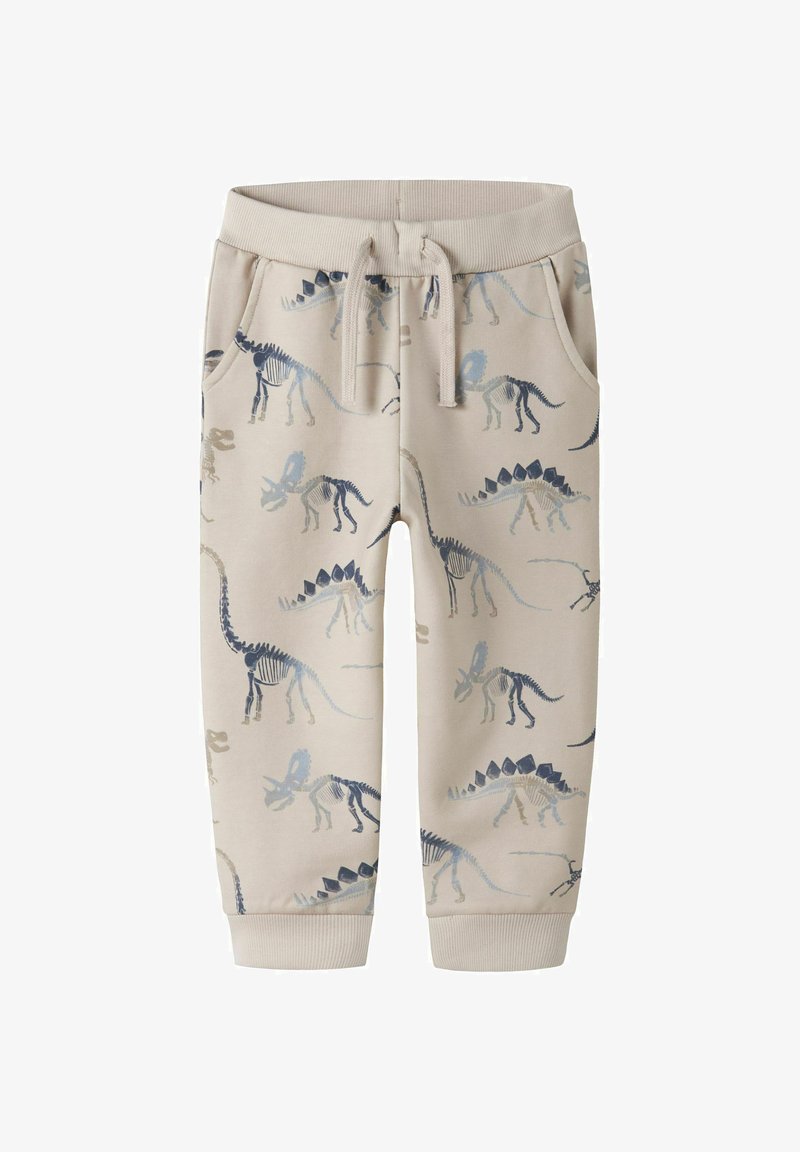 Pantalon de survêtement beige pour enfants avec motifs de squelettes de dinosaures en nuances de bleu et gris, doté d'une taille élastique et d'un cordon de serrage.
