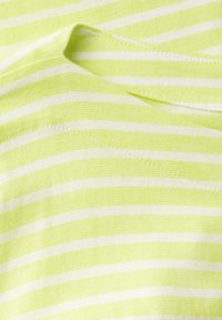 Pruhovaný top ze světle zelené a bílé látky, s hladkým povrchem, kulatým výstřihem a viditelnými švy.