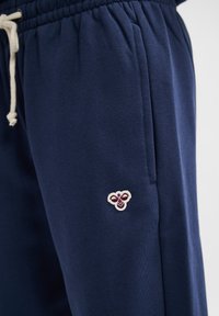 Pantaloni jogging blu navy realizzati in un morbido misto cotone; caratterizzati da un elastico in vita con cordino e un piccolo logo ricamato a forma di ape.