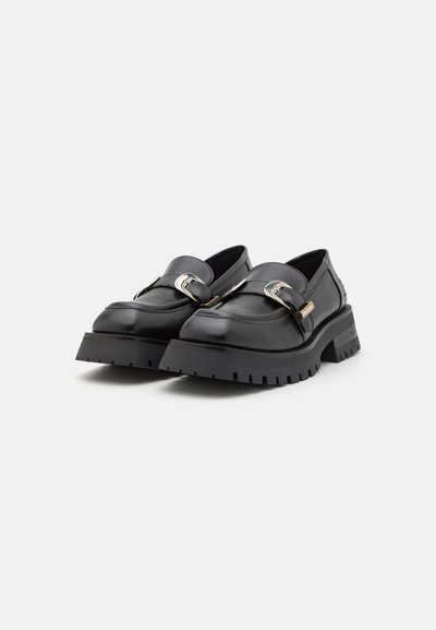 Melnas ādas loafers ar apaļu purngalu, ar dekoratīvu sudraba sprādzi un izturīgu, teksturētu zoli, kas nodrošina labāku saķeri.