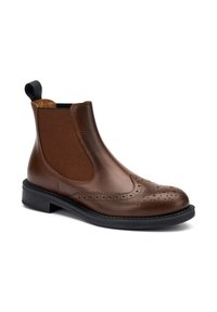 Stivale Chelsea in pelle marrone con dettagli brogue, pannello elastico laterale, suola nera e linguetta sul retro.