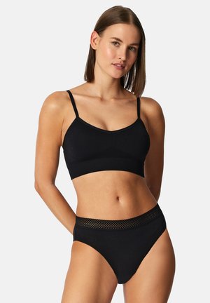 Black bralette with thin straps and a V-neck, paired with high-waisted black briefs featuring a textured mesh waistband.