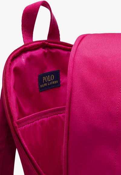 Rucsac roz aprins cu finisaj textil neted, având un interior spațios, o etichetă cusută în interior și o mâner robust în partea de sus.