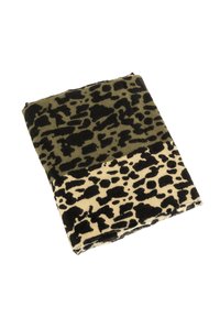 Couverture en polaire rectangulaire avec un motif animalier en vert olive et beige, ornée de taches noires. Texture douce, repliée soigneusement.