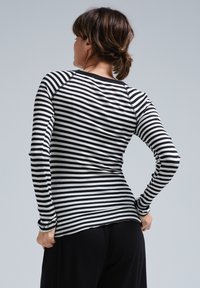 Schwarz-weißer gestreifter Langarmshirt mit Rippstruktur, rundem Ausschnitt und taillierter Passform, von hinten betrachtet.