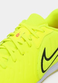 Scarpa atletica gialla neon con il baffo Nike nero, lacci gialli e tomaia in tessuto a rete.