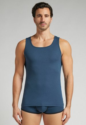 Marineblaues geripptes Tanktop mit rundem Ausschnitt. Hat einen figurbetonten Schnitt und besteht aus einem weichen, dehnbaren Stoff. Wird mit passenden Slips kombiniert.