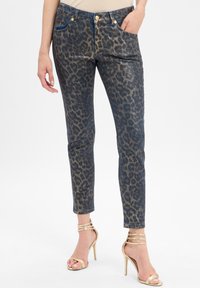 Jeans en denim à imprimé léopard dans des tons bleu foncé et or, présentant une coupe slim, un design à cinq poches et des accents en métal doré.