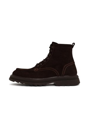 Stivaletto alla caviglia in camoscio marrone scuro con suola spessa in gomma nera e dettagli di cuciture visibili su sfondo bianco.