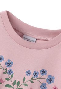 Lyserød T-shirt med rund halsudskæring, prydet med farverige blomster mønstre i blå og pink på forsiden. Blødt, bomuldsstof.