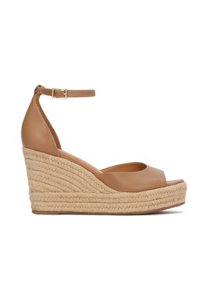 Sandali con zeppa in pelle color cuoio, con punta aperta, cinturino alla caviglia e plateau rivestito in juta. Caratterizzati da una finitura liscia e suola texturizzata.
