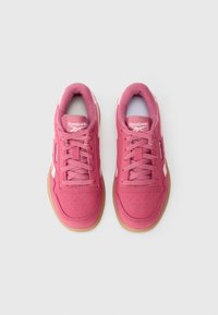 Ténis Reebok cor-de-rosa com um superior texturizado, fecho de atacadores, língua acolchoada e sola de borracha natural. Detalhes brancos nas laterais e na marca.