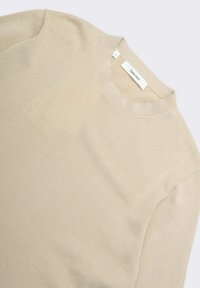 Maglione beige lavorato a maglia con scollo rotondo, caratterizzato da un tessuto testurizzato, dettagli sottili a coste sul collo e un'etichetta con la scritta "Selected".