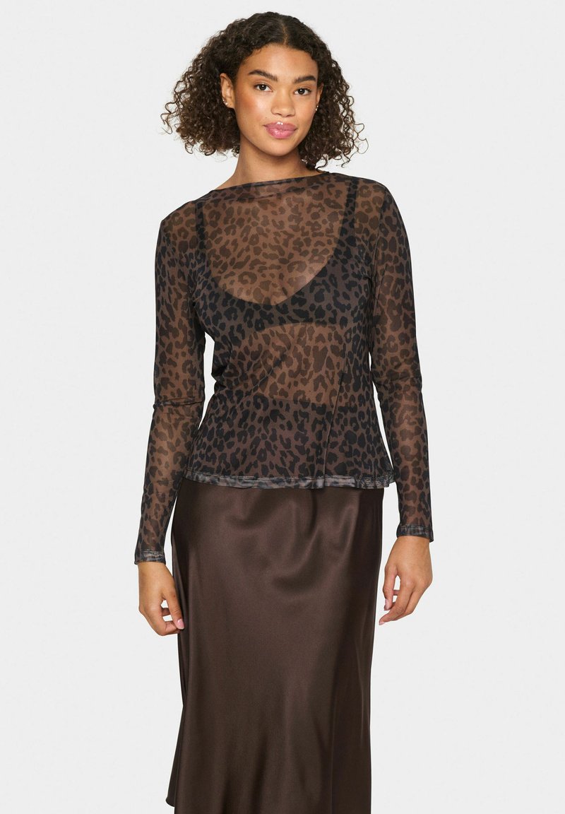 Črna leopardja vzorčasta dolgosleeve prosojna bluza z okroglim izrezom in oprijetim krojem, položena čez satensko rjavo krilo.