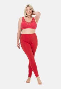 Set di reggiseno e leggings rossi con bordo in pizzo. Tessuto morbido, design aderente. Il reggiseno presenta un fiocco al centro; i leggings hanno una vita elastica.