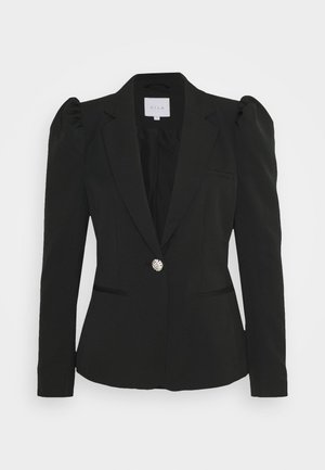 Veste noire cintrée pour femme avec épaules structurées, un bouton décoratif unique et des revers étroits, présentée sur un fond clair uni.