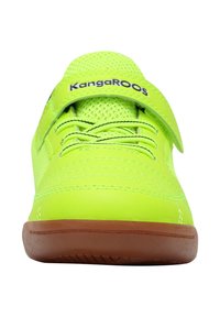 Heller grüner Turnschuh mit Klettverschluss, der mit "KangaROOS" beschriftet ist, grünen Schnürsenkeln, Netzobermaterial und brauner Gummisohle, von vorne gesehen.